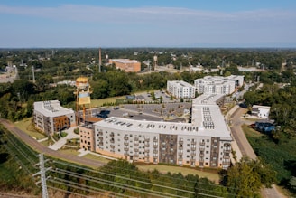 Modern apartment buildings surrounded by trees and greenery.