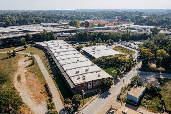Vista aérea de una nave industrial moderna con su patio de estacionamiento, terreno de la agencia de SEO en México