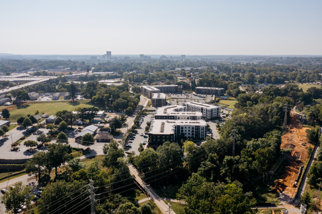 Modern apartment buildings surrounded by lush green trees.