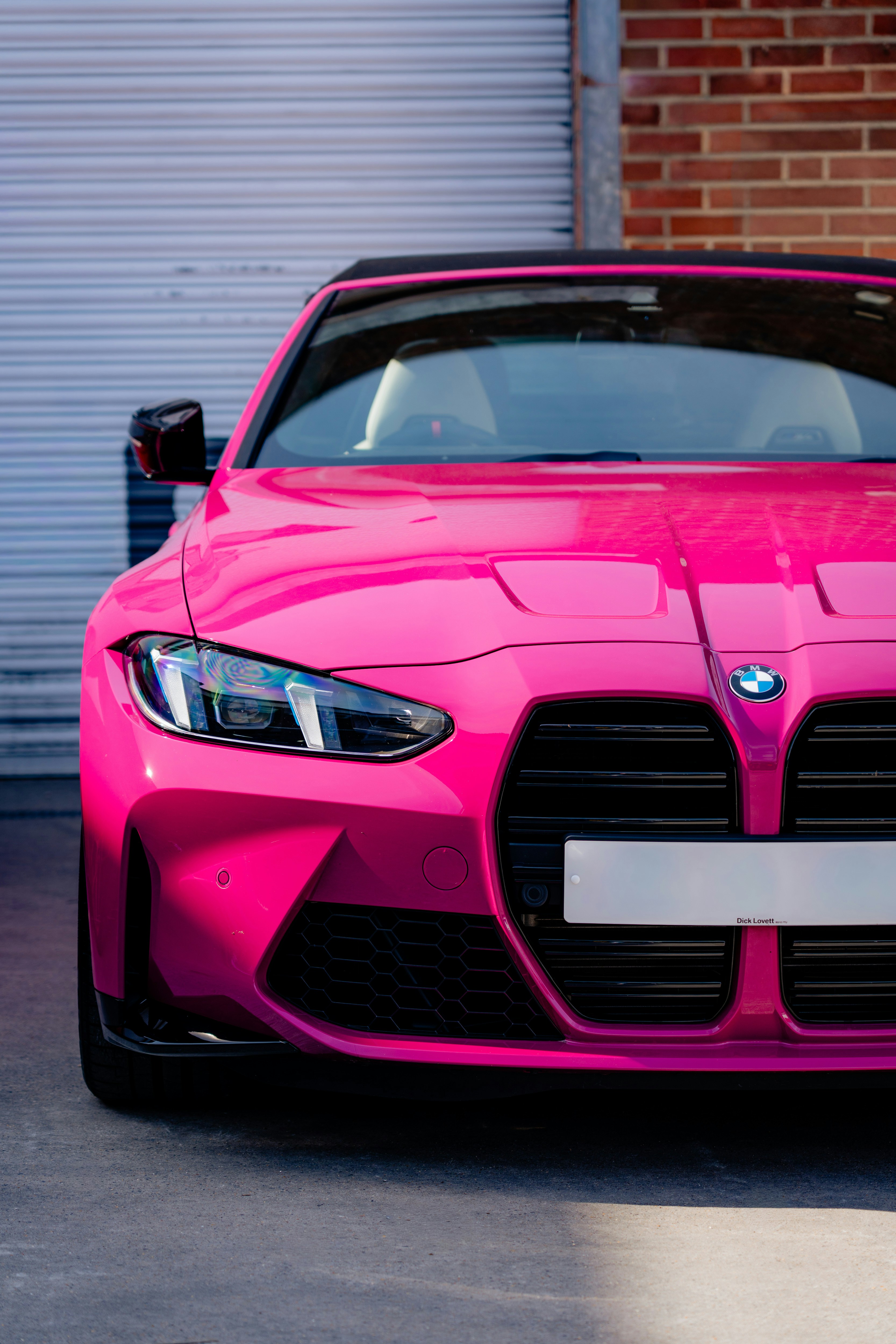 Bright pink BMW convertible parked outdoors