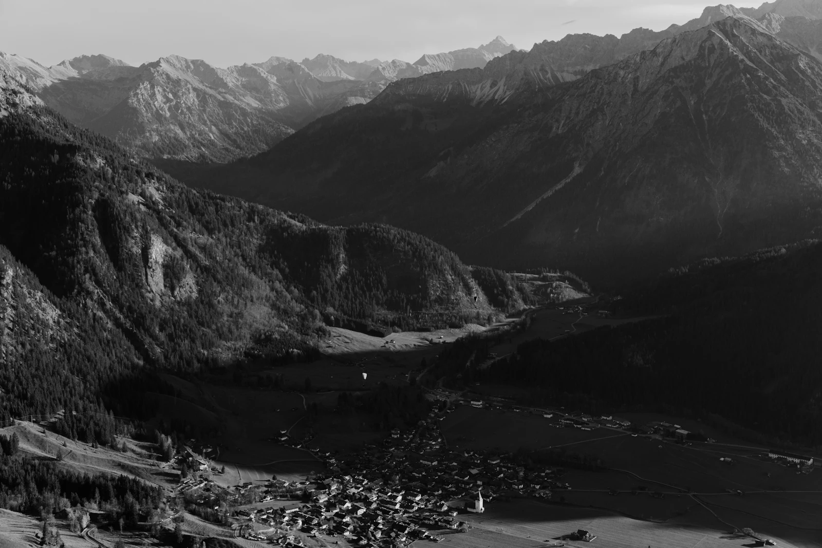 Village de montagne blotti dans une vall&eacute;e cern&eacute;e de sommets (image d'illustration)