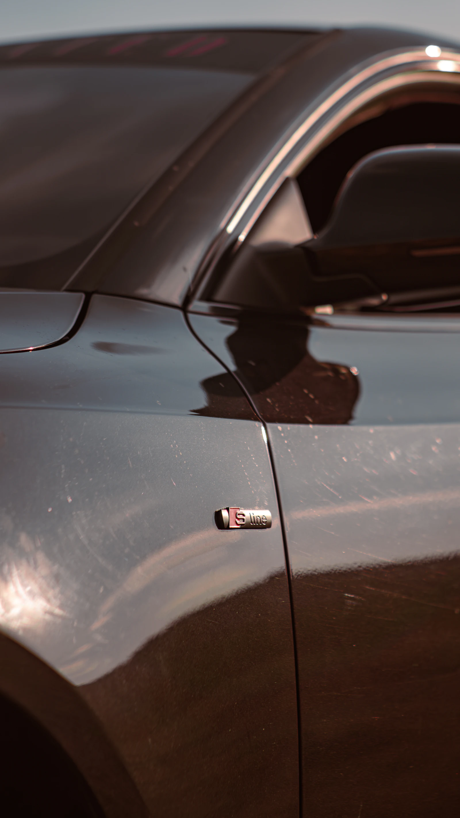Dark car fender with badge