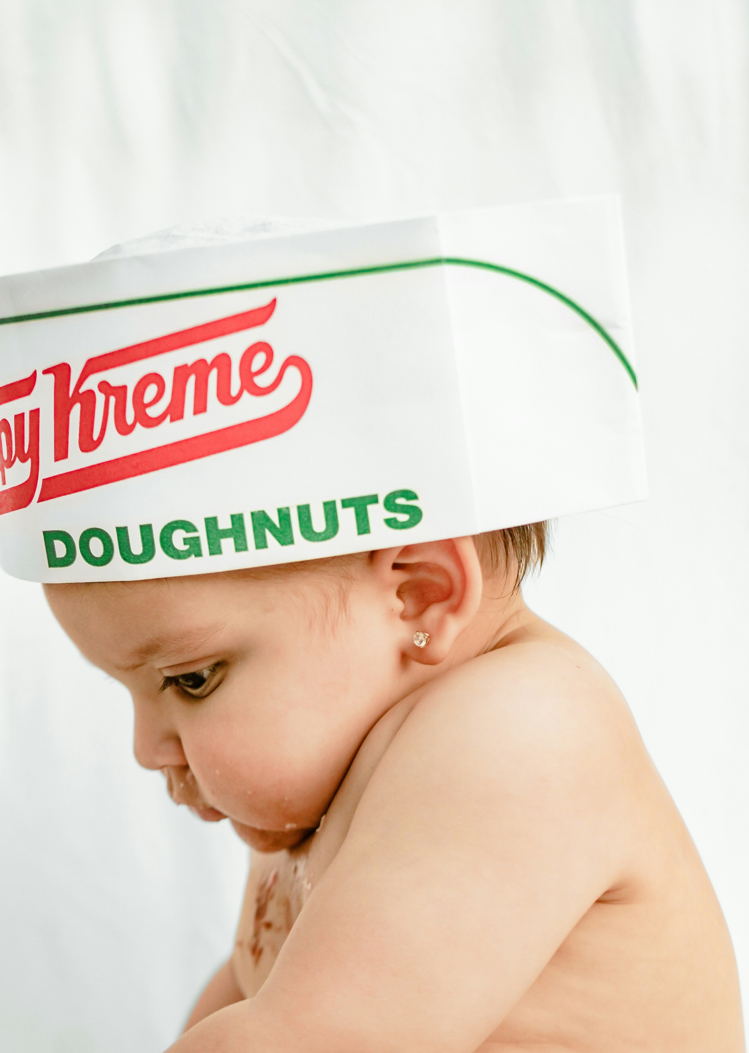 Baby wearing a krispy kreme hat