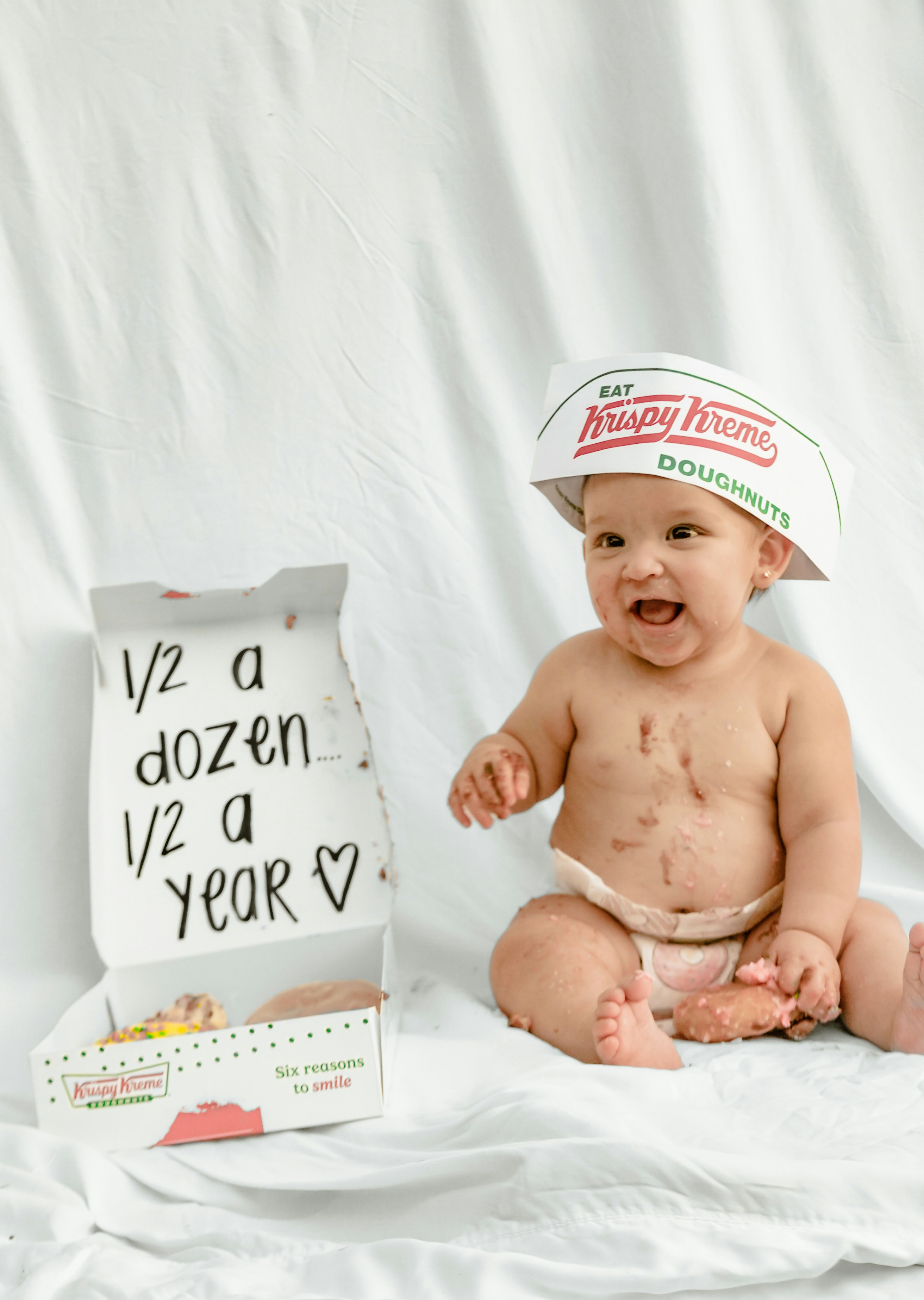 Baby in krispy kreme hat with half dozen box