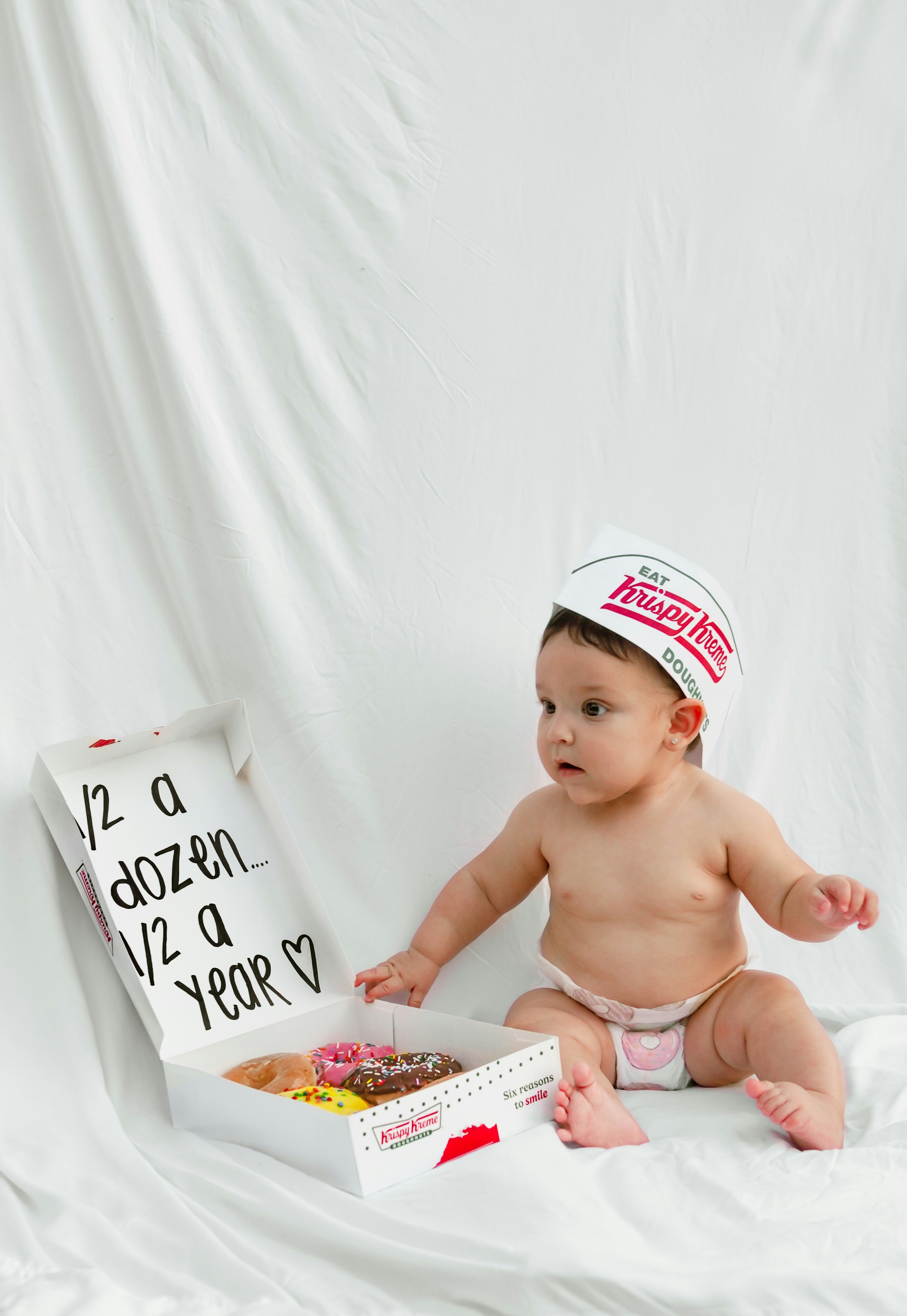 Baby with donuts and a krispy kreme hat