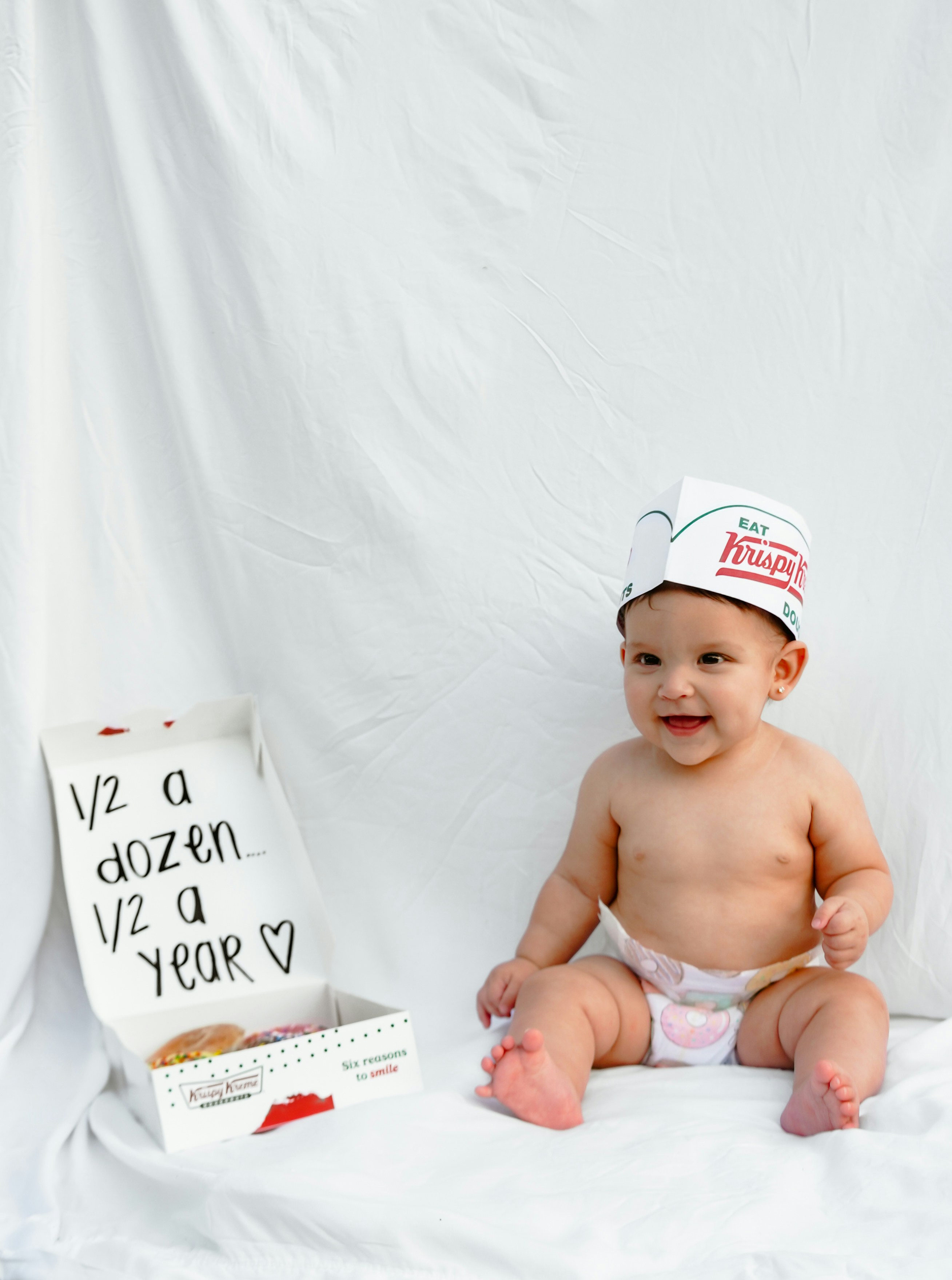 Baby in donut hat with half dozen box