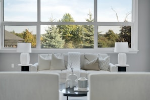 Modern living room with large window overlooking trees