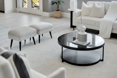 Modern living room with white sofa and round coffee table.