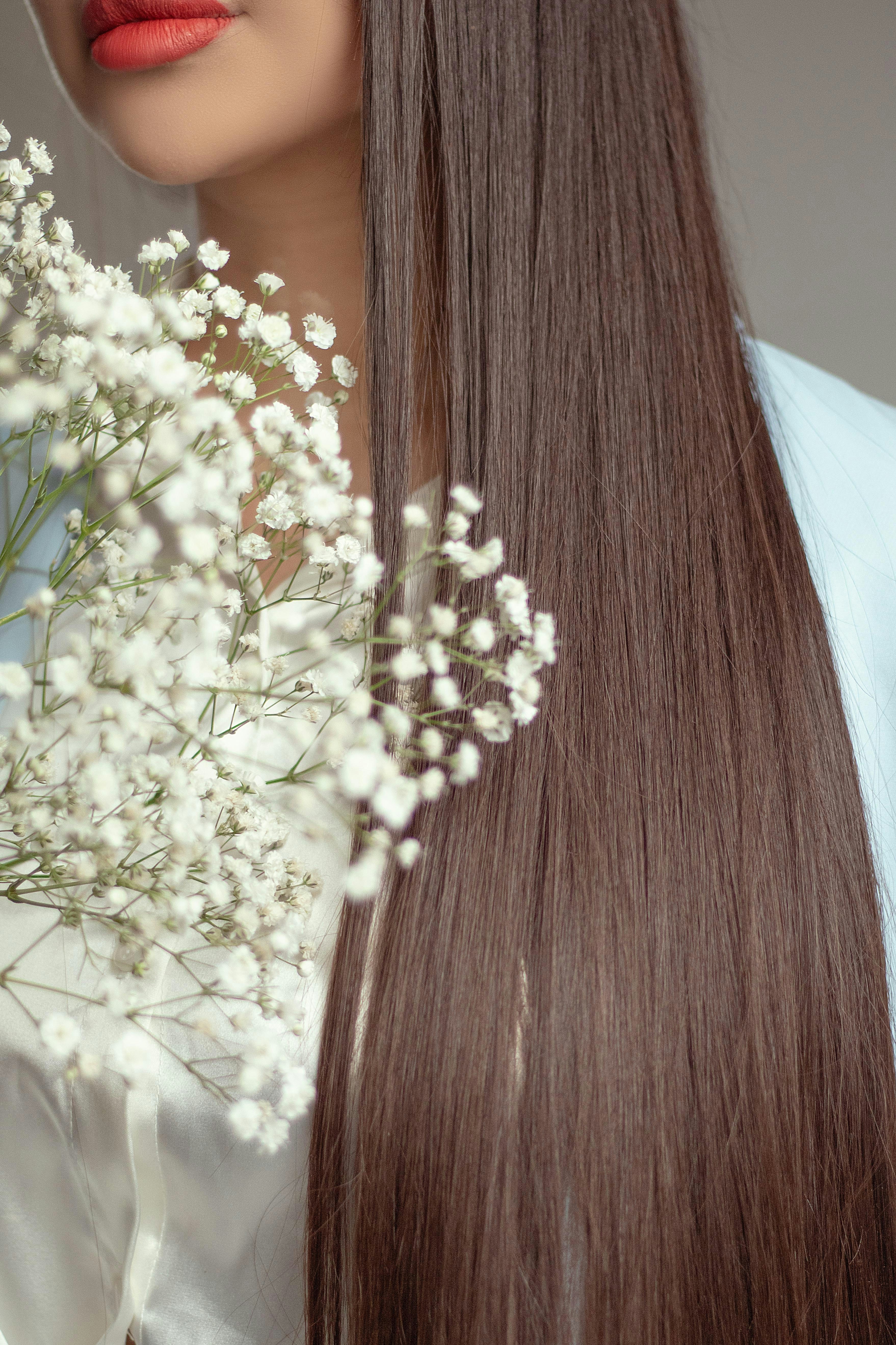 Woman with long brown hair holding white flowers