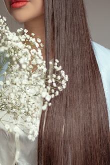 Woman with long brown hair holding white flowers