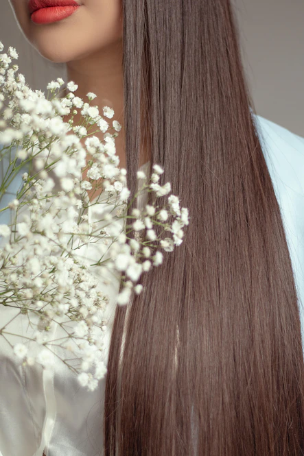 Woman with long brown hair holding white flowers