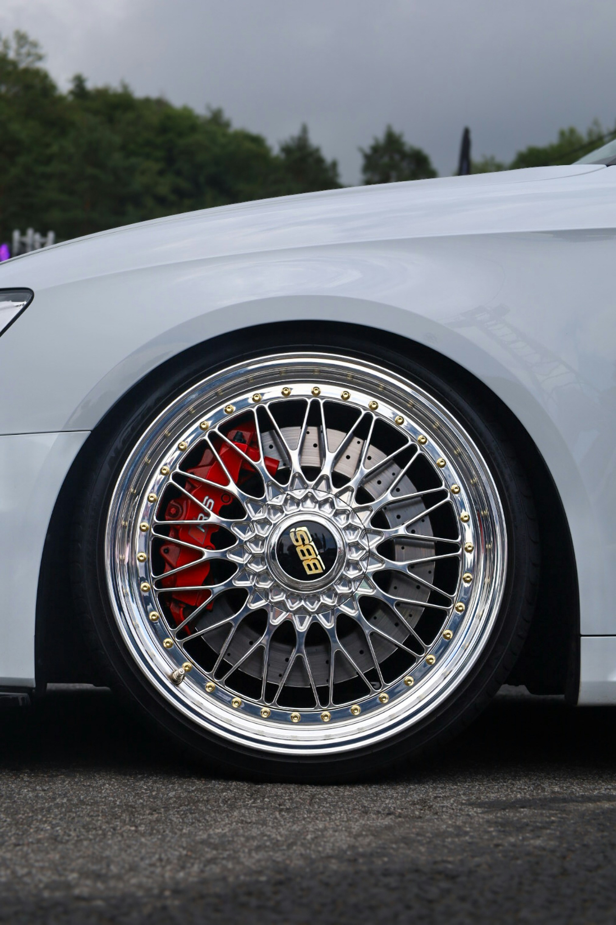 Close-up of a shiny car wheel with red brake caliper.