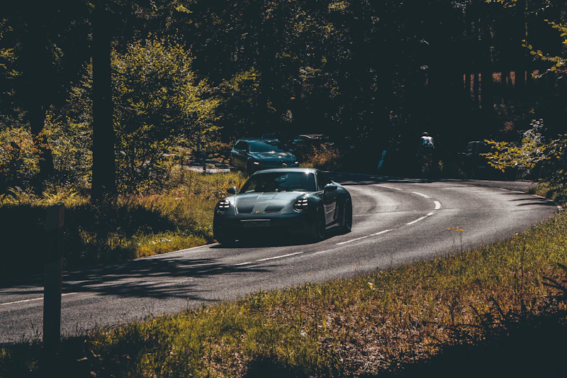 Zwei Luxusautos auf kurviger Waldstraße