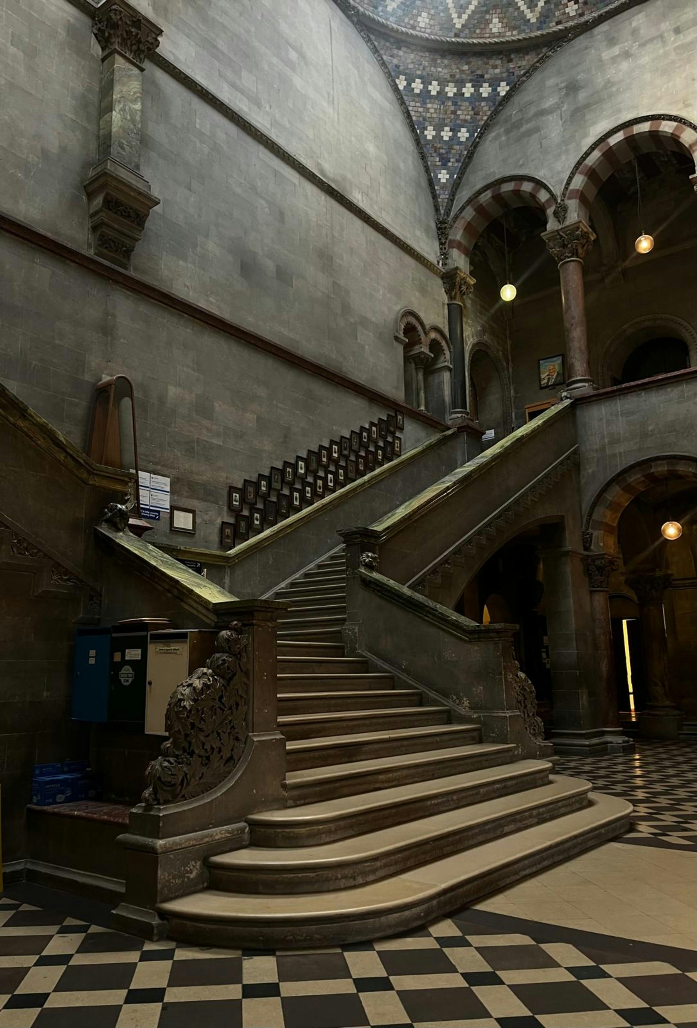 Große Treppe in einem alten Gebäude mit kariertem Boden.