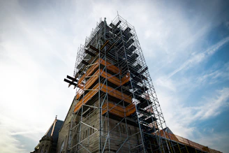 Stone tower under construction with scaffolding.