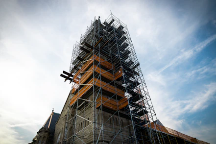 Stone tower under construction with scaffolding.
