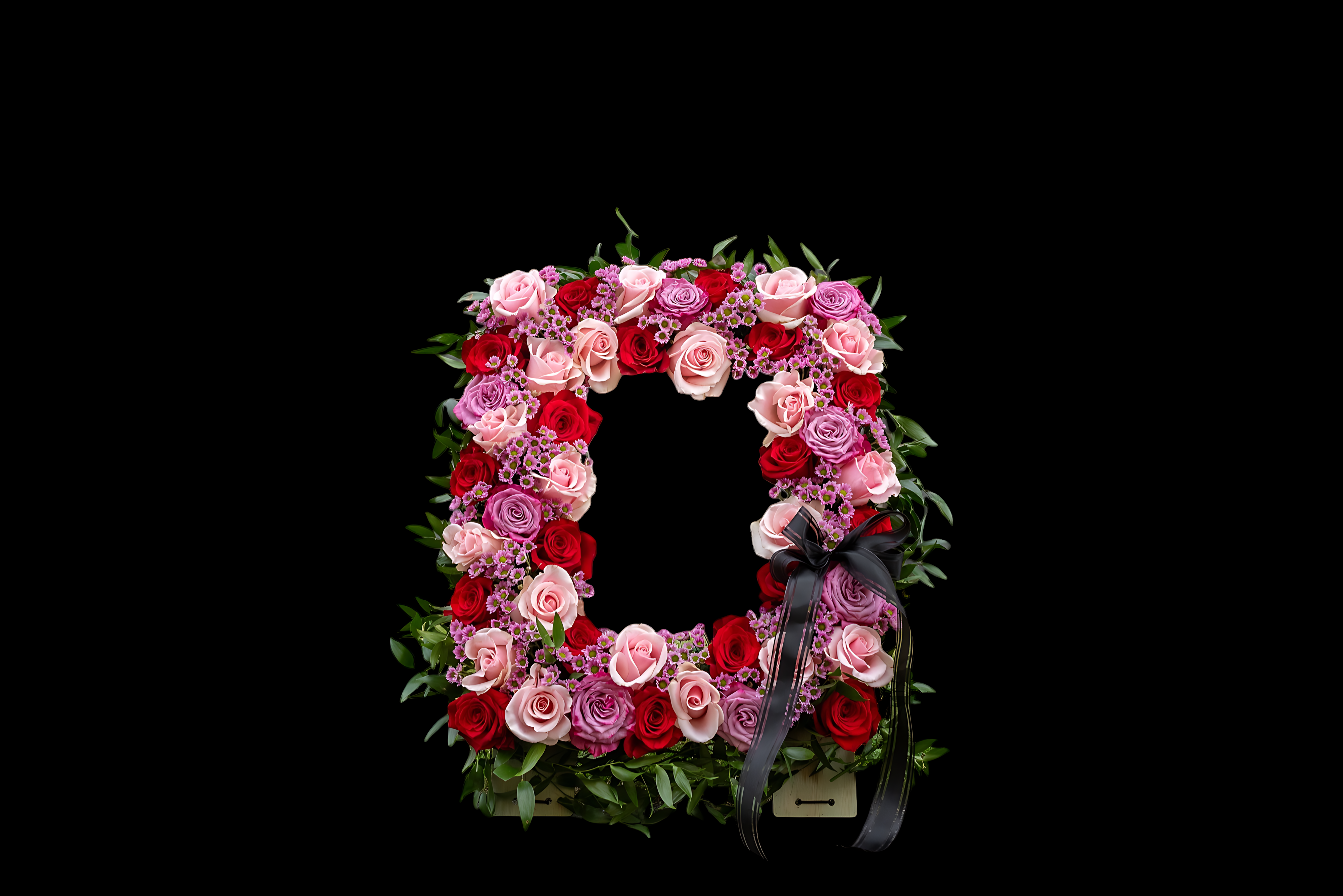 A square wreath of pink and red roses on black.
