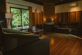 A modern recording studio with soundproofing and large window.