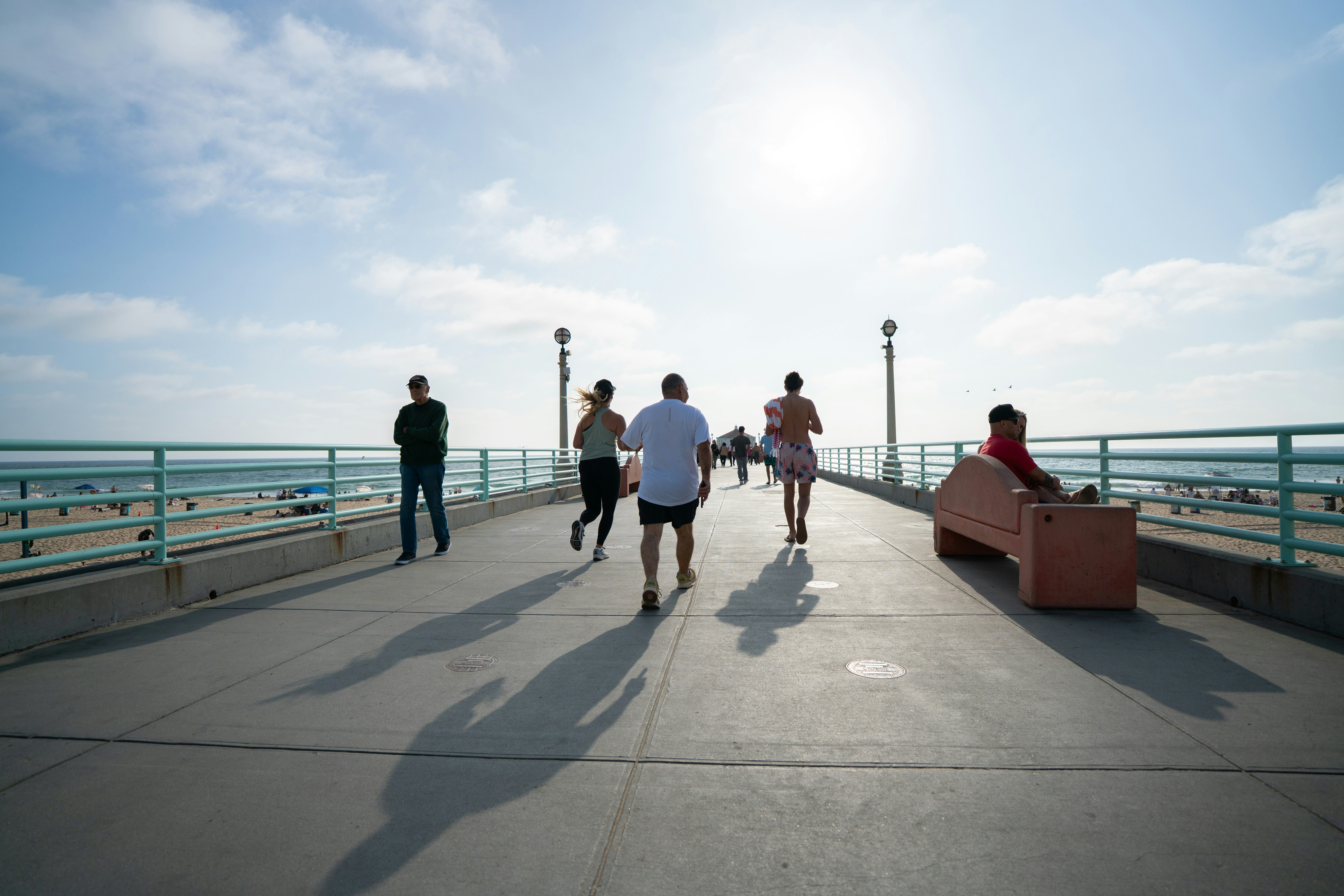 Pessoas correndo em um cais com fundo oceânico