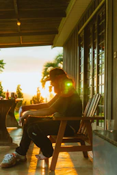 Man sitting on porch during sunset