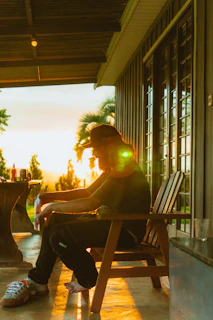 Man sitting on porch during sunset