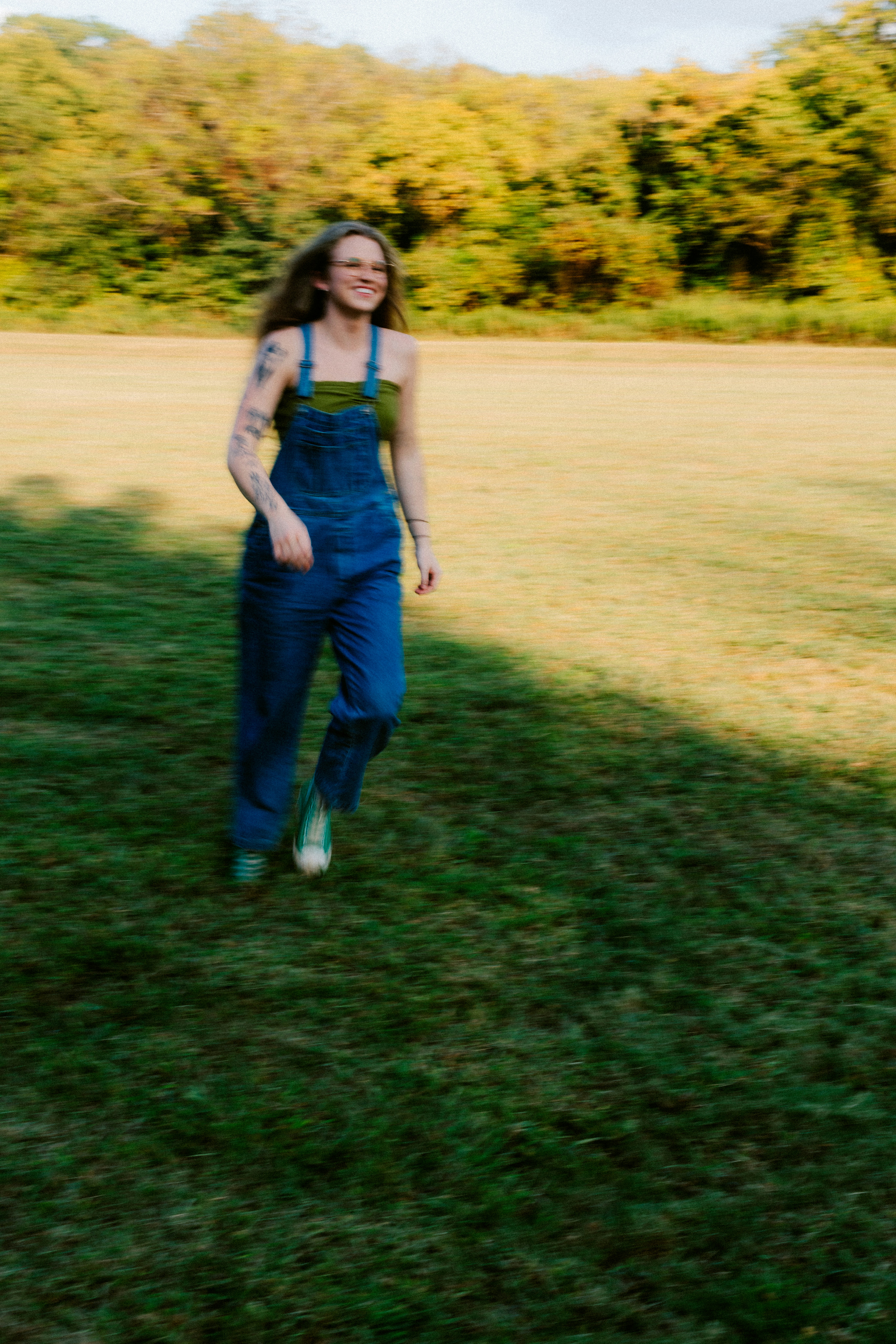 Femme marchant dans un champ avec une salopette en jean