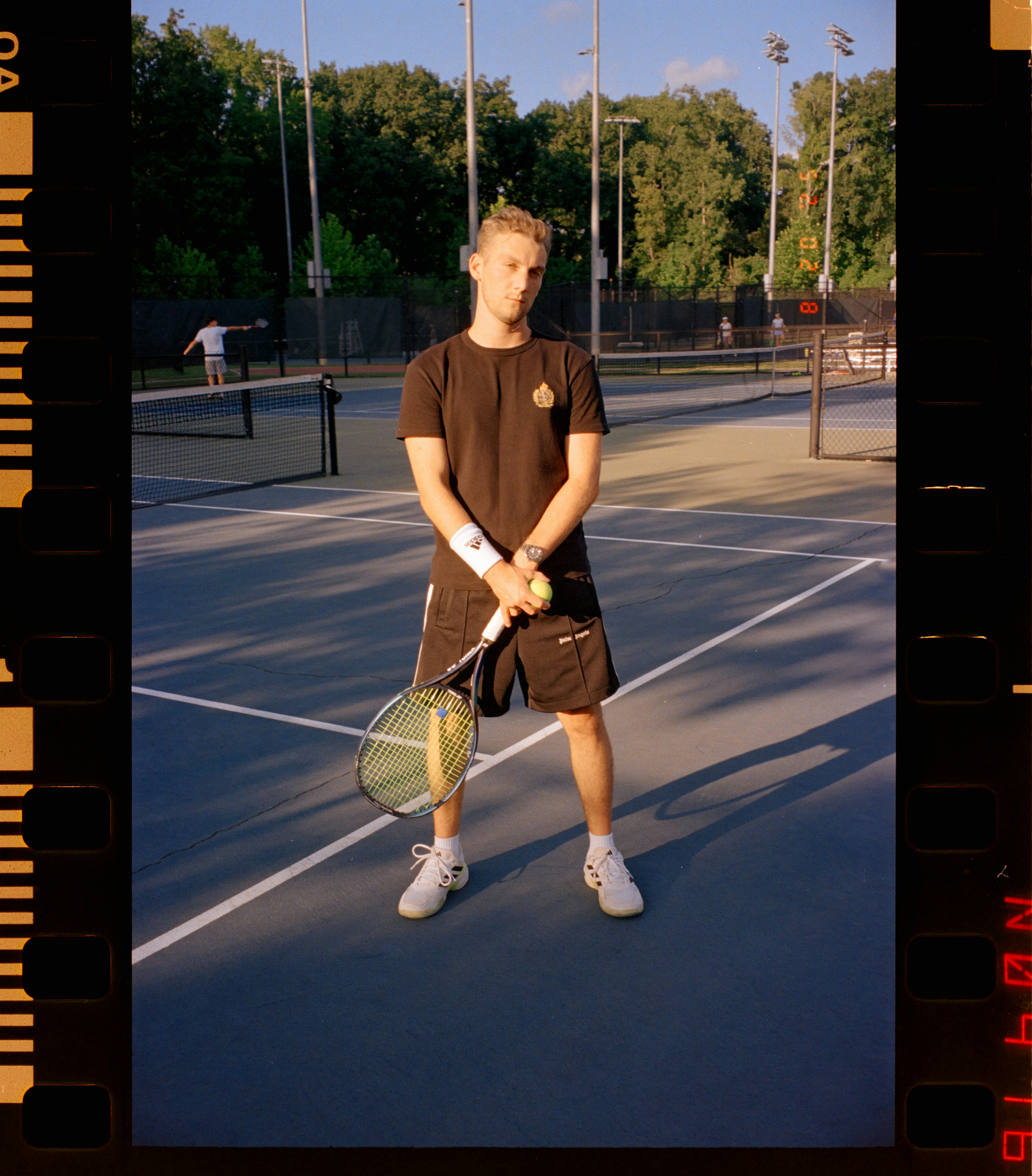 Jeune homme tenant une raquette de tennis sur le court