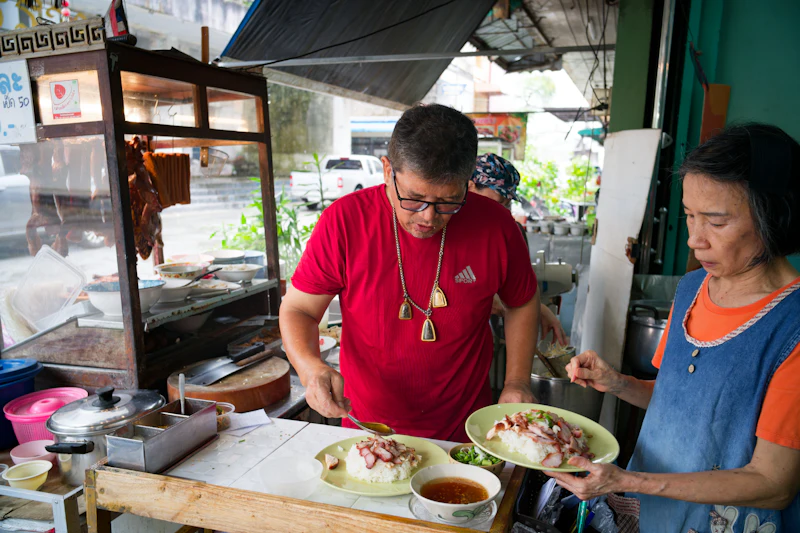 Dos cocineros preparando comida en un puesto de street food