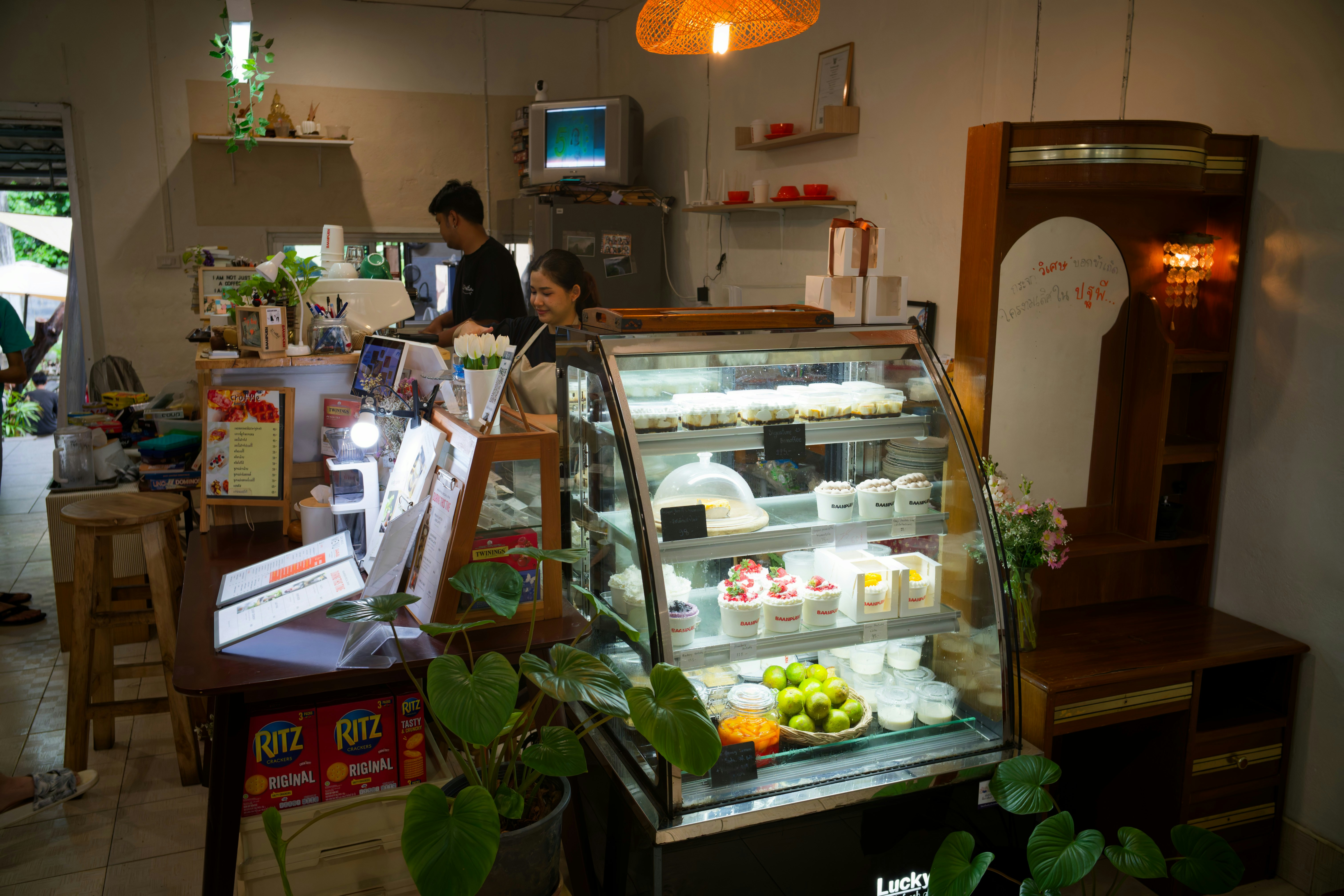 Dessert display case in a cozy cafe interior.