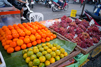 Oranges, tangerines, and grapes displayed at a market.