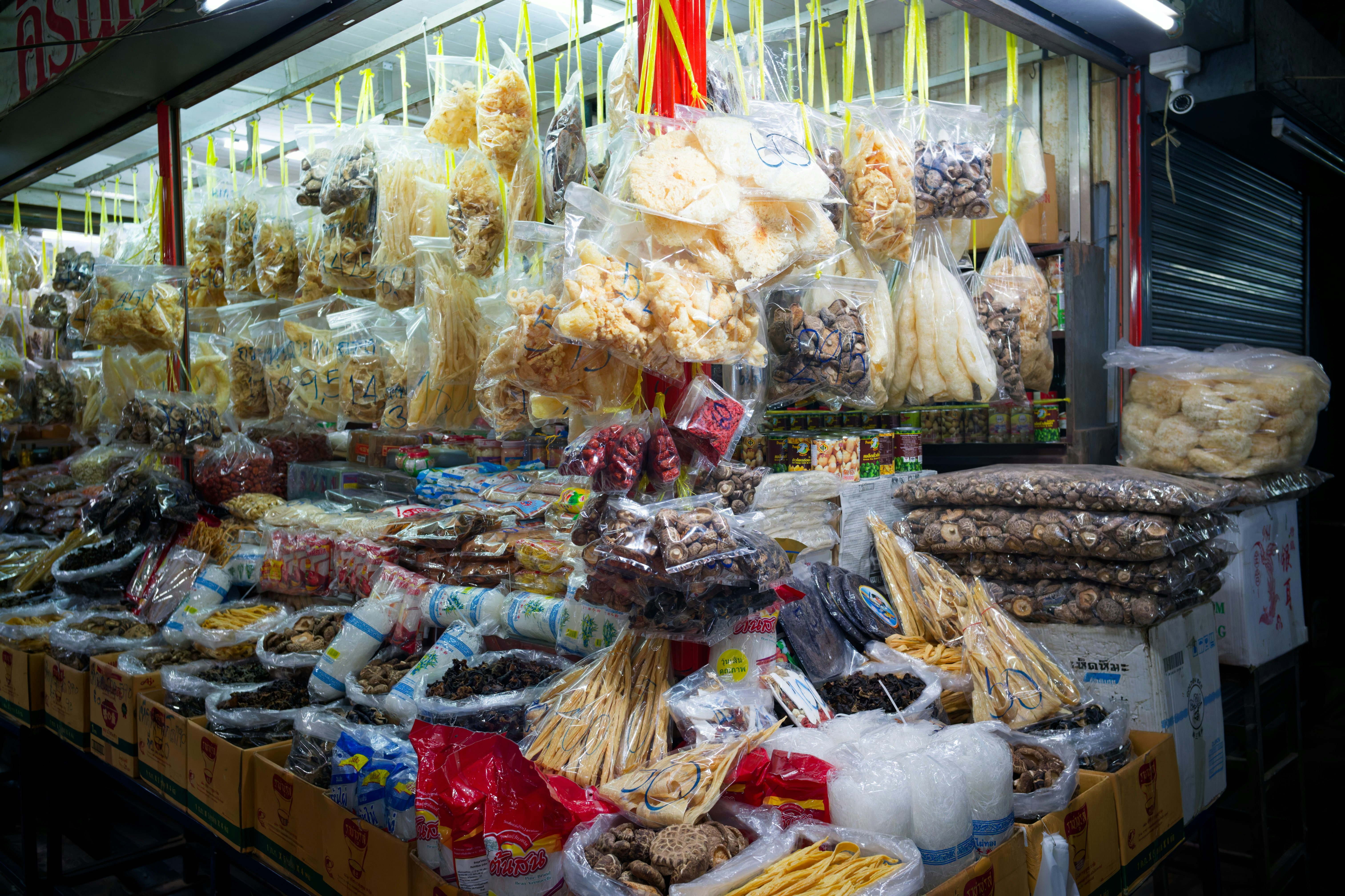 Stall selling various dried goods and snacks in bags.