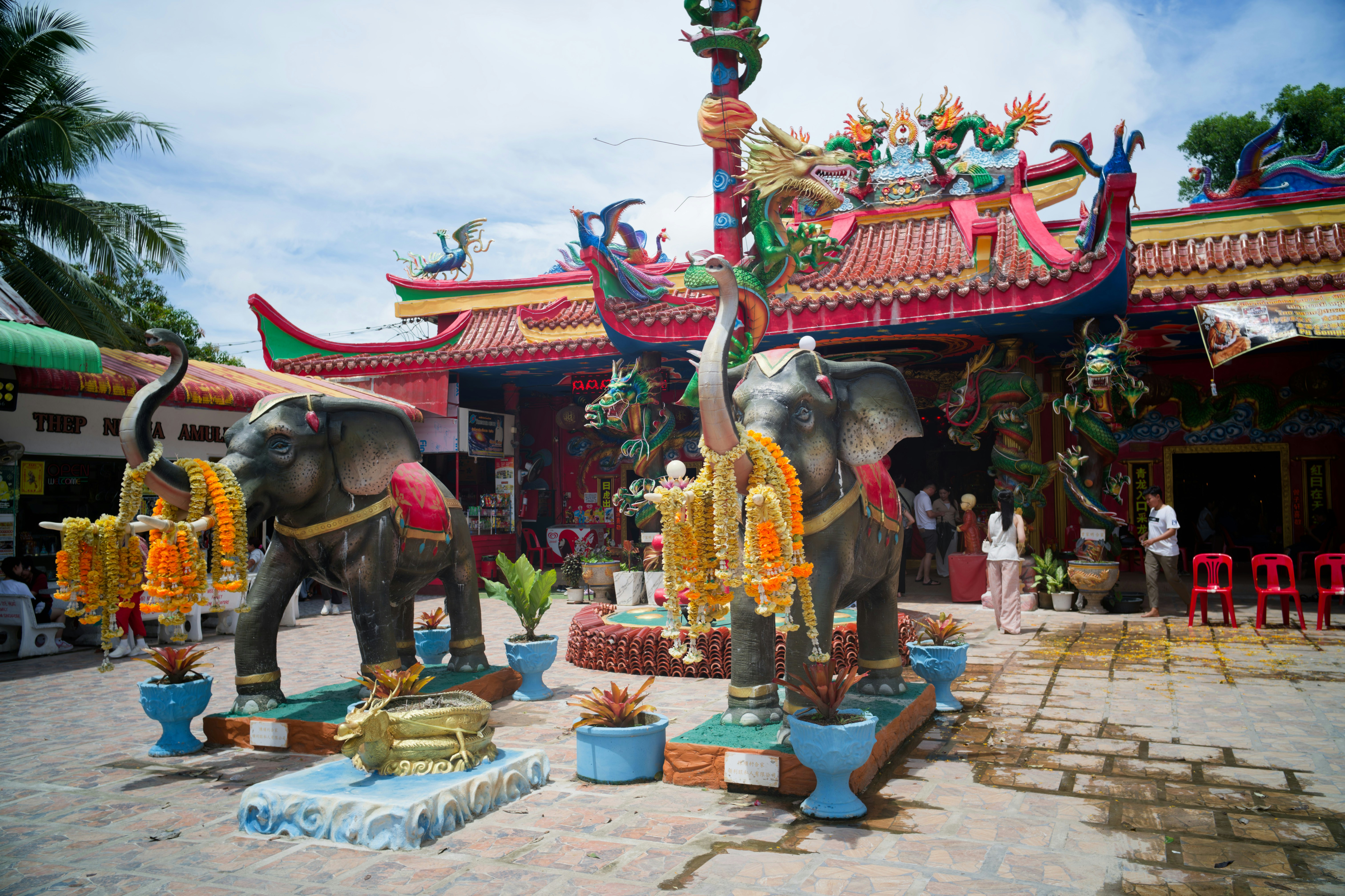 Two elephant statues flanking a colorful temple entrance