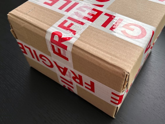 Cardboard box sealed with red fragile tape