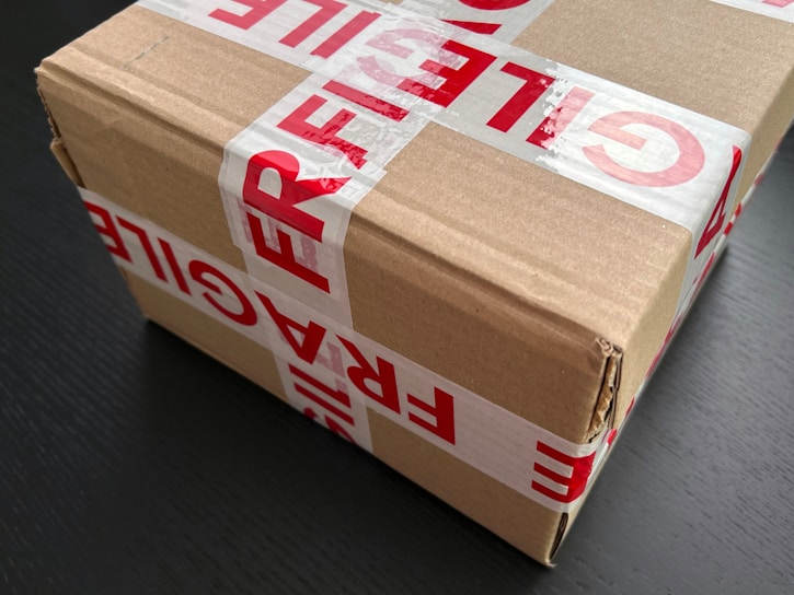 Cardboard box sealed with red fragile tape