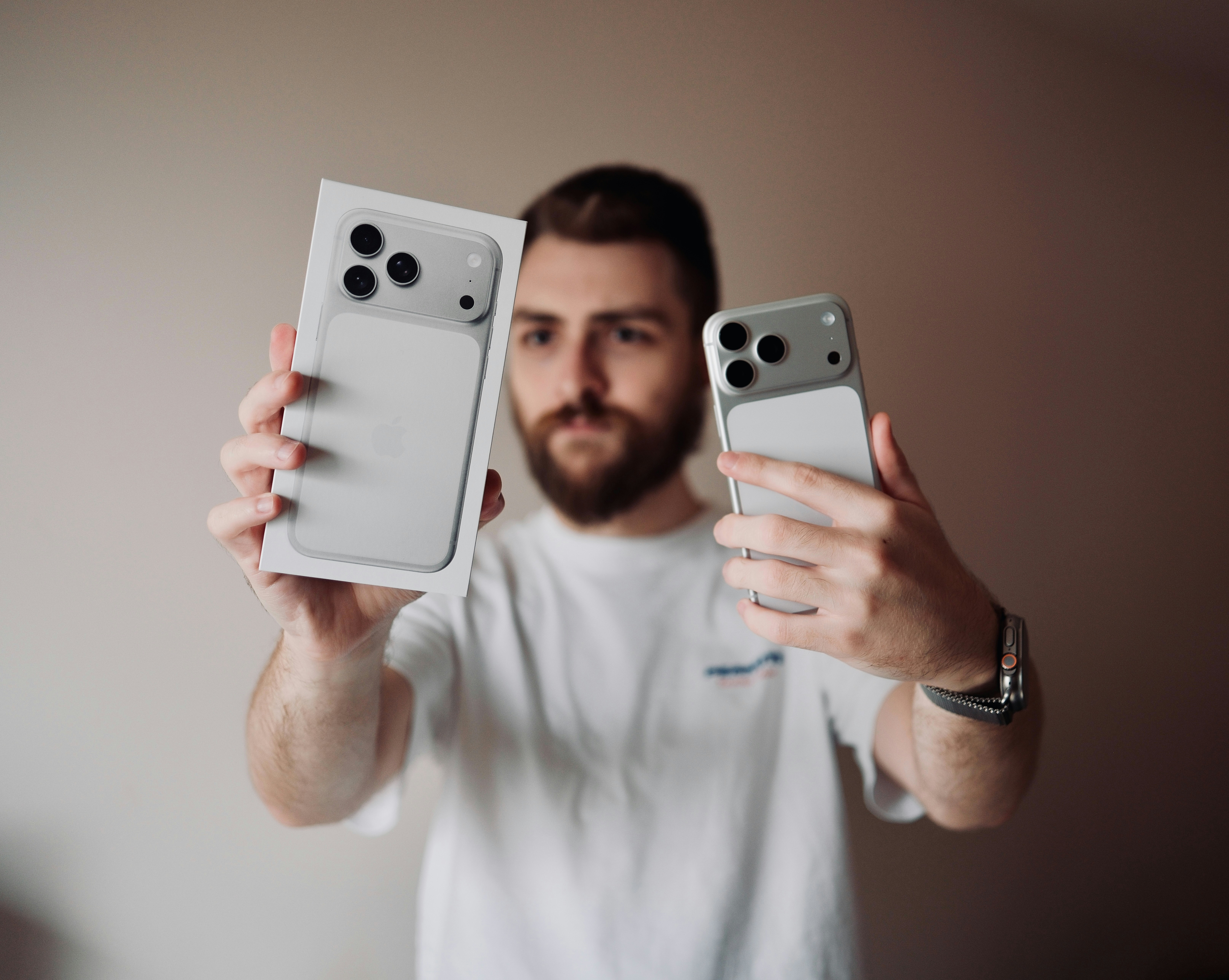 Hombre sosteniendo un iPhone y su caja