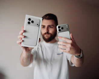 Man holding an iPhone and its box