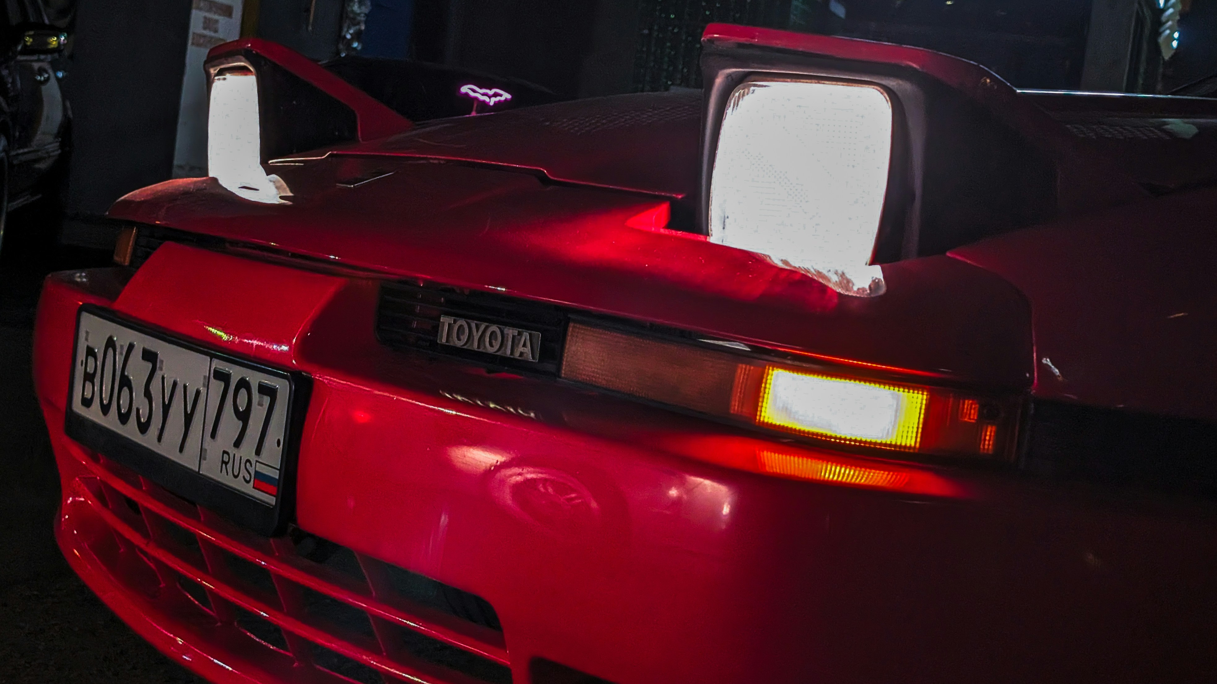 Toyota supra merah dengan lampu depan menyala