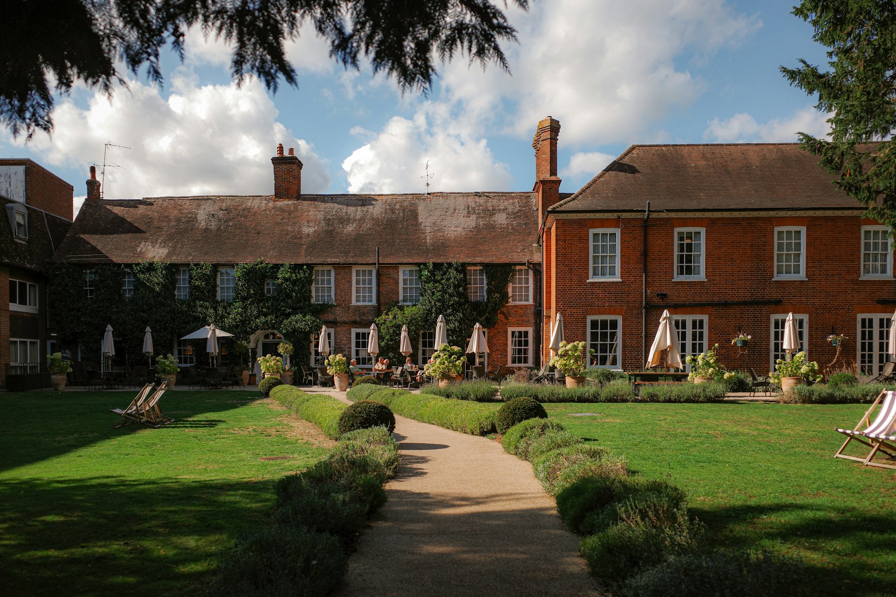 Traditional English garden with seating outside a brick townhouse