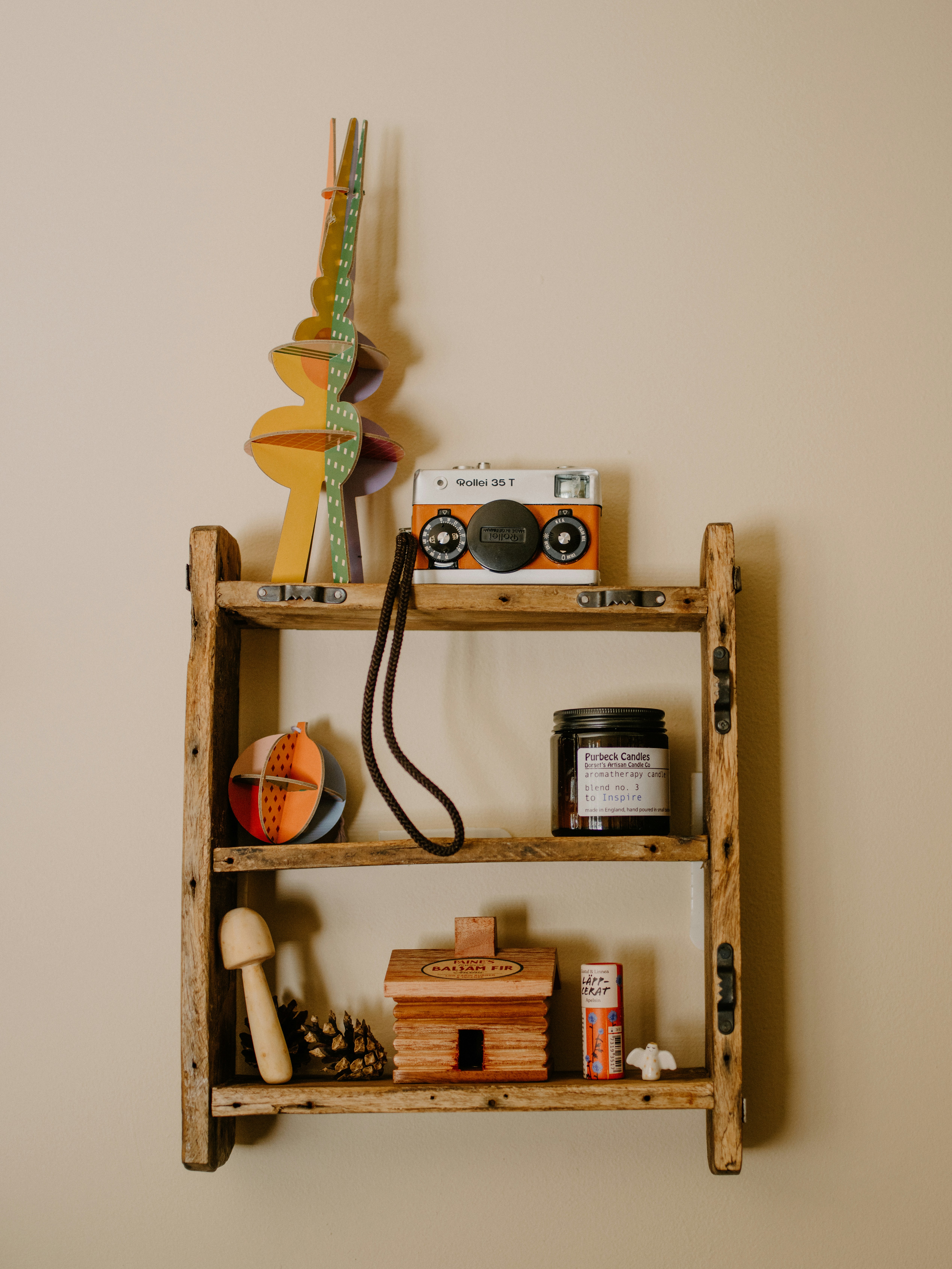 Wooden shelf with decorative items and vintage camera.