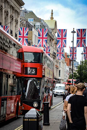 Red double-decker buses on a street adorned with union jacks.