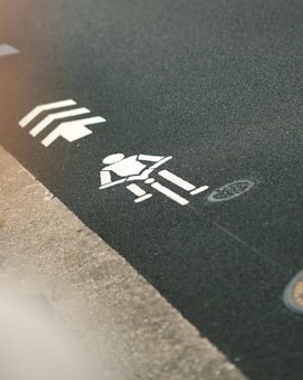 White cyclist symbol painted on asphalt path