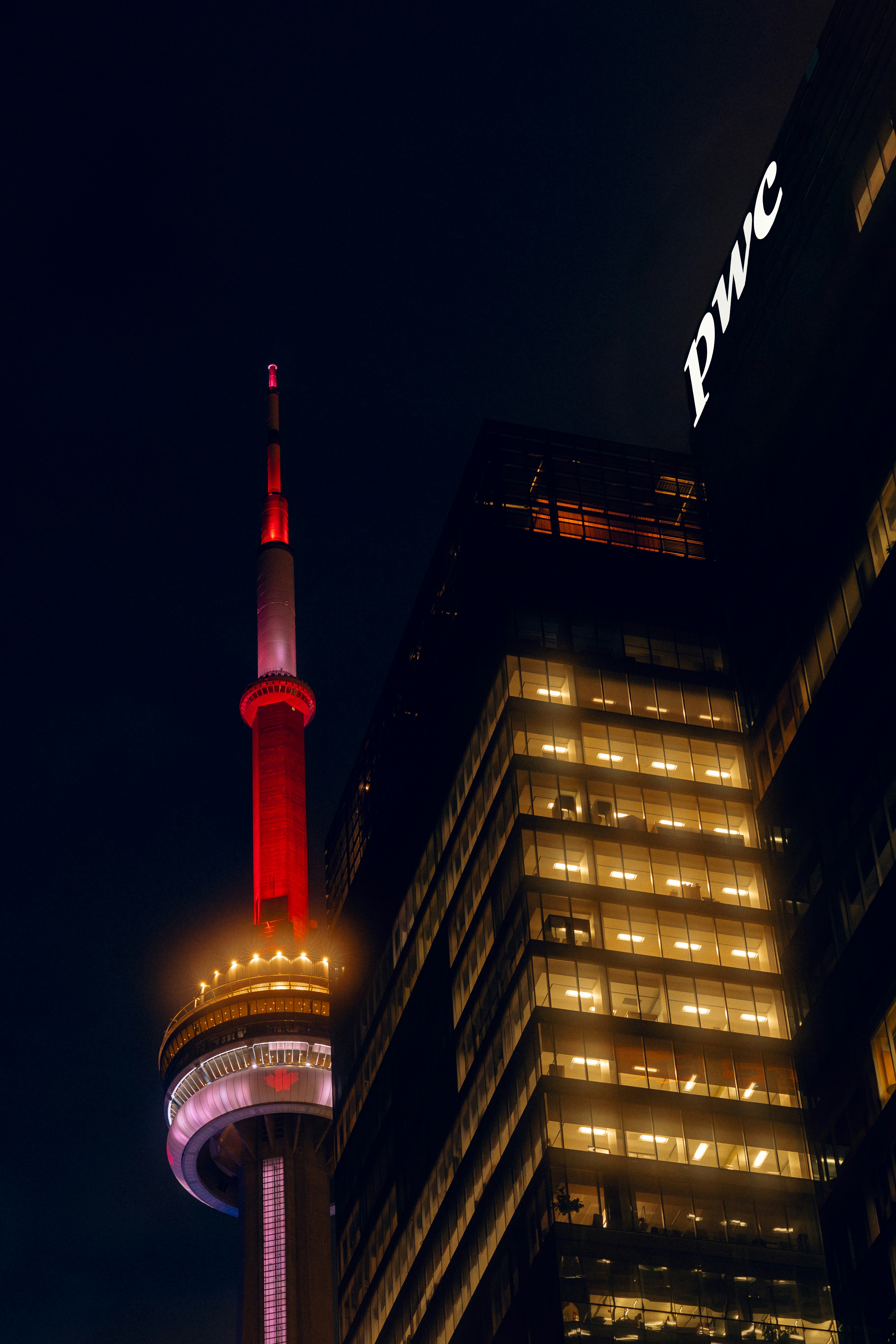 Cn tower and illuminated skyscrapers at night.