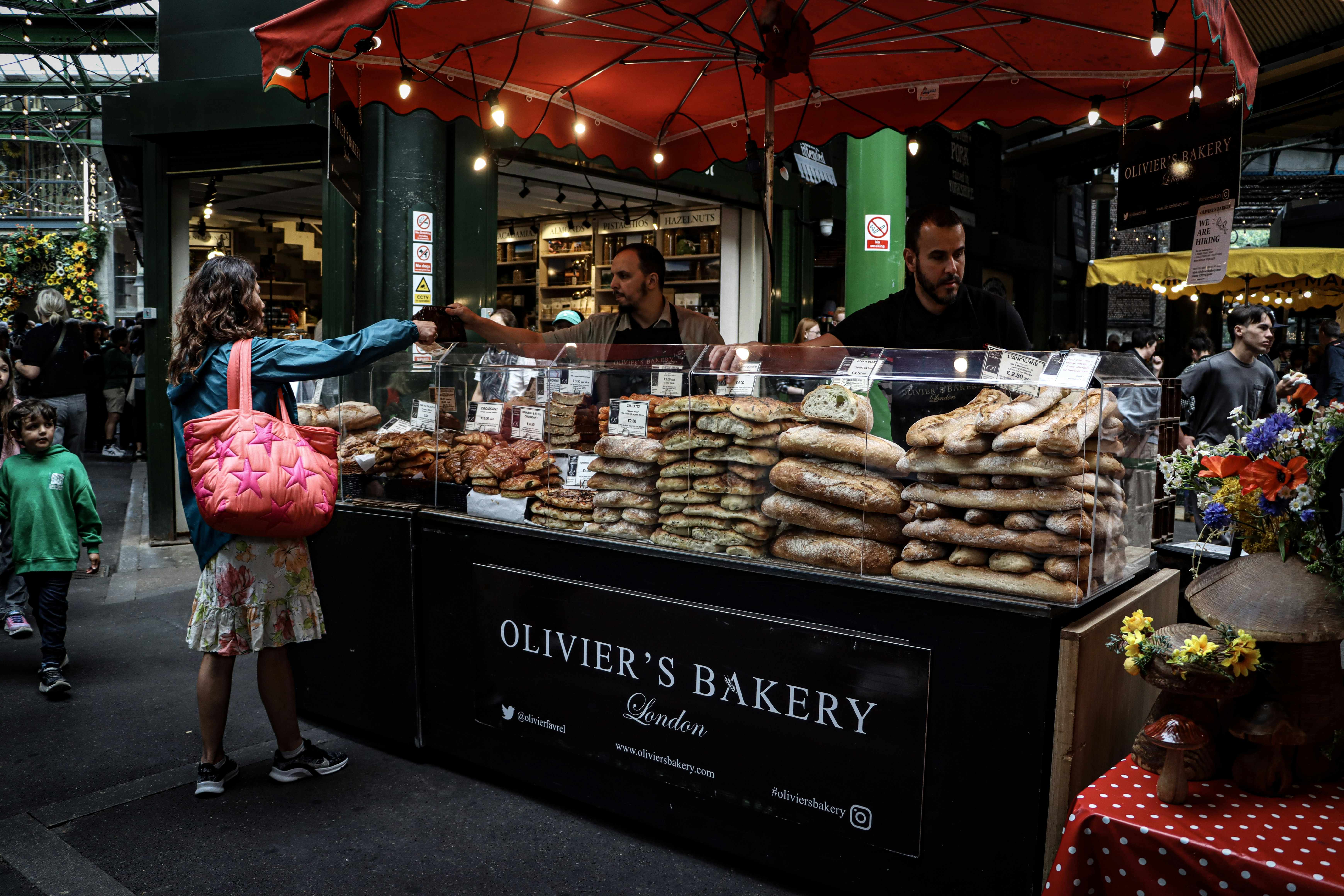 People at a bakery stall selling bread and pastries