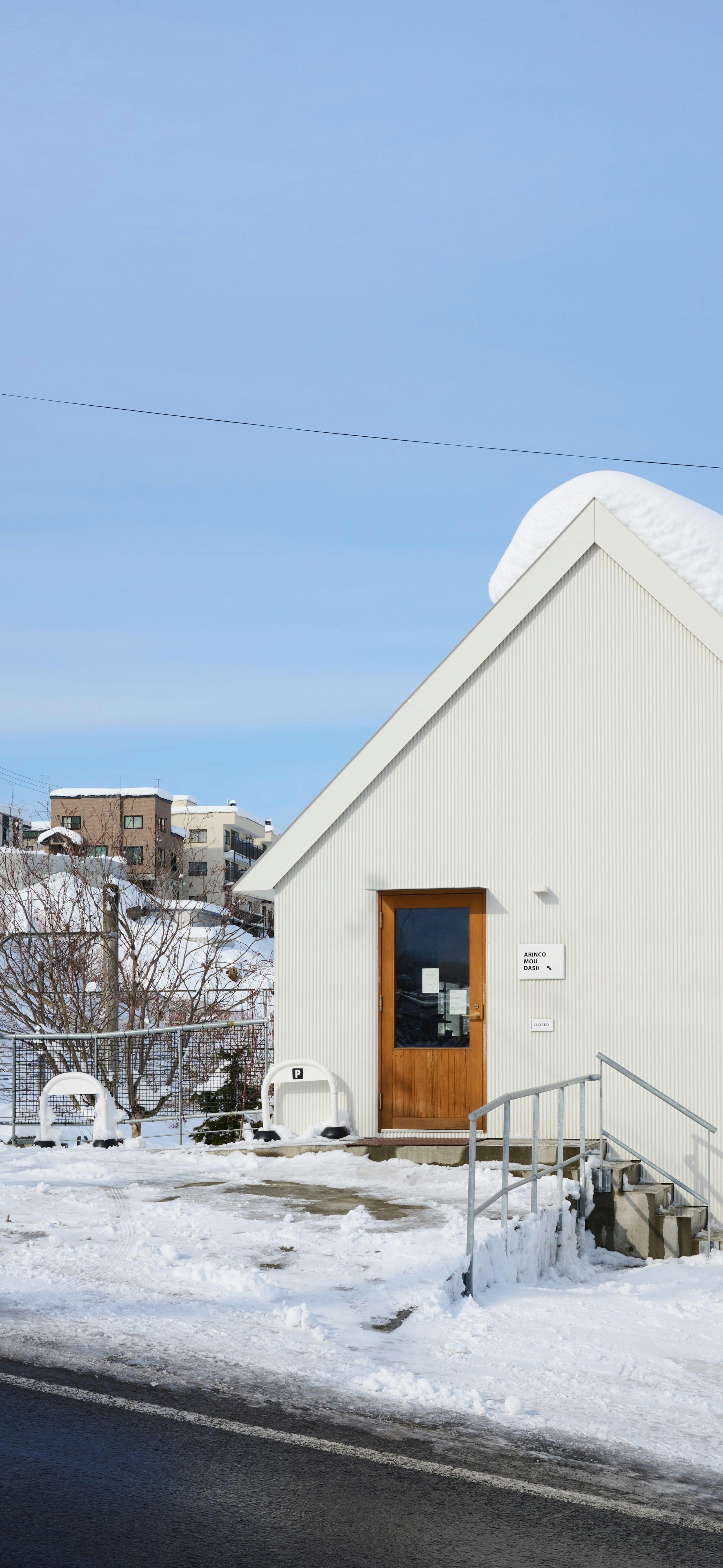 A white building covered in snow under a clear sky.