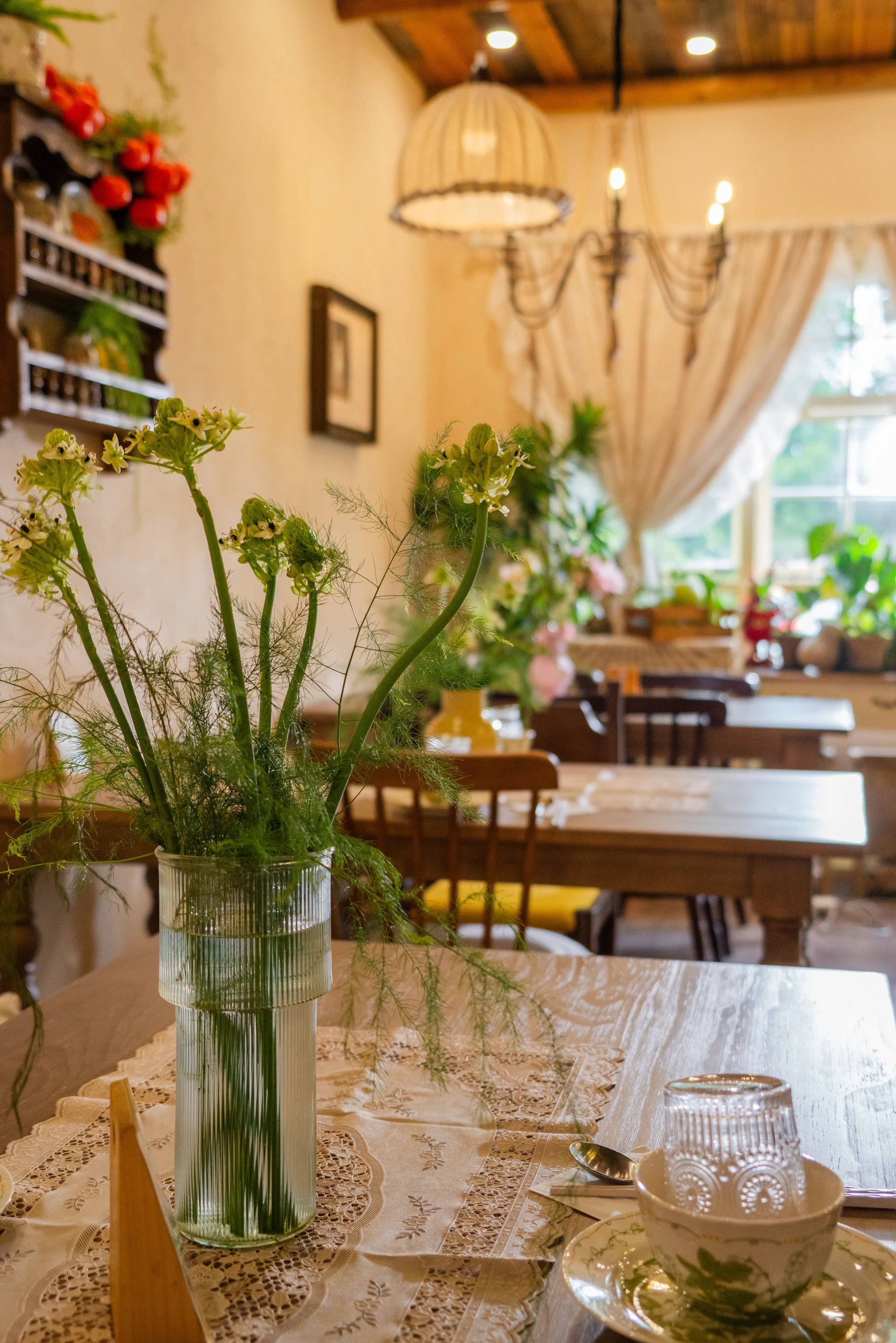 A vase of greenery on a table setting