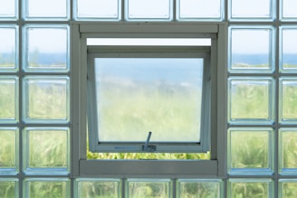 Open window in glass block wall overlooking landscape