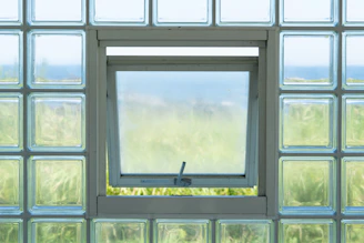 Open window in glass block wall overlooking landscape