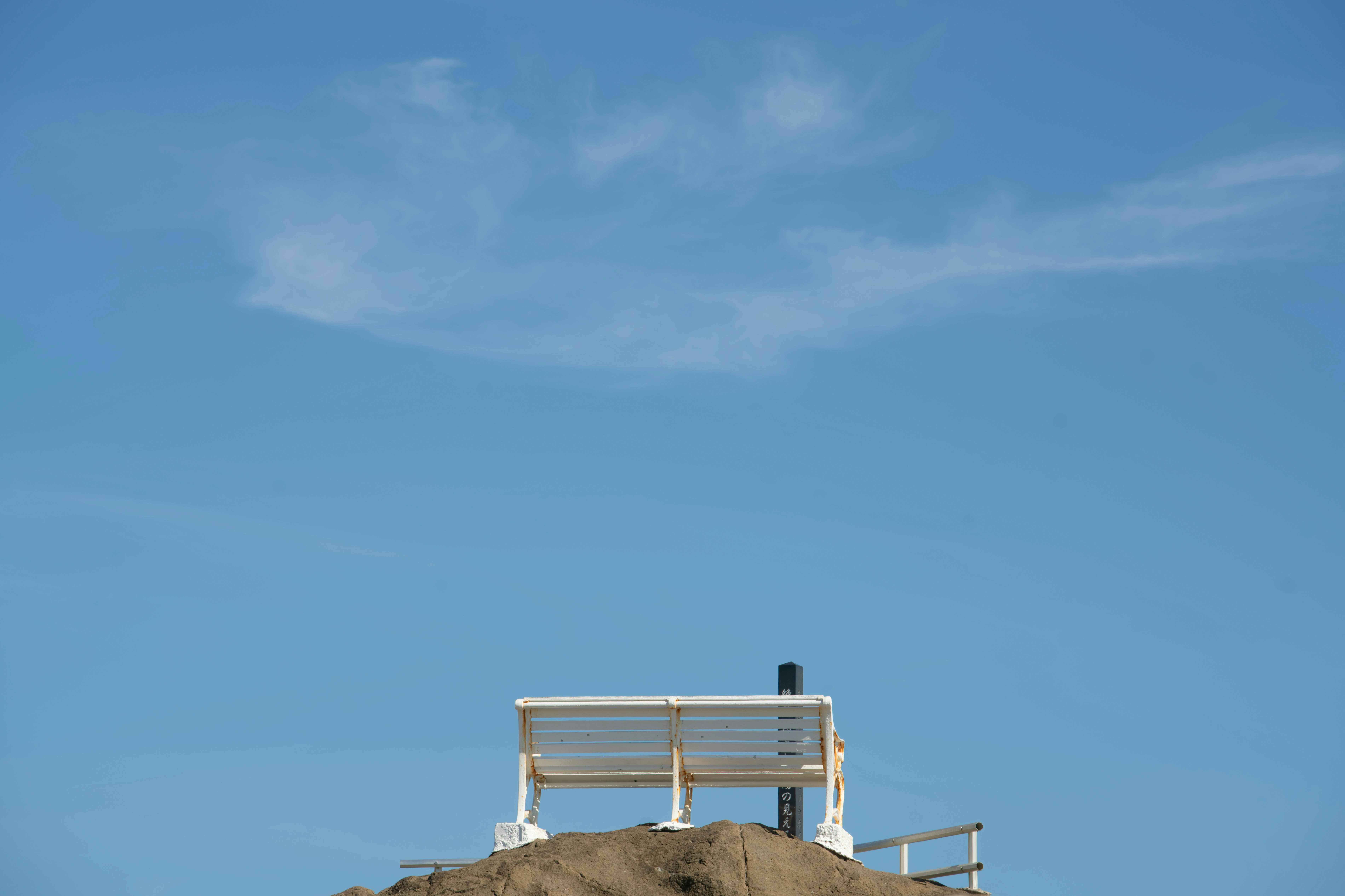 White bench on sand dune