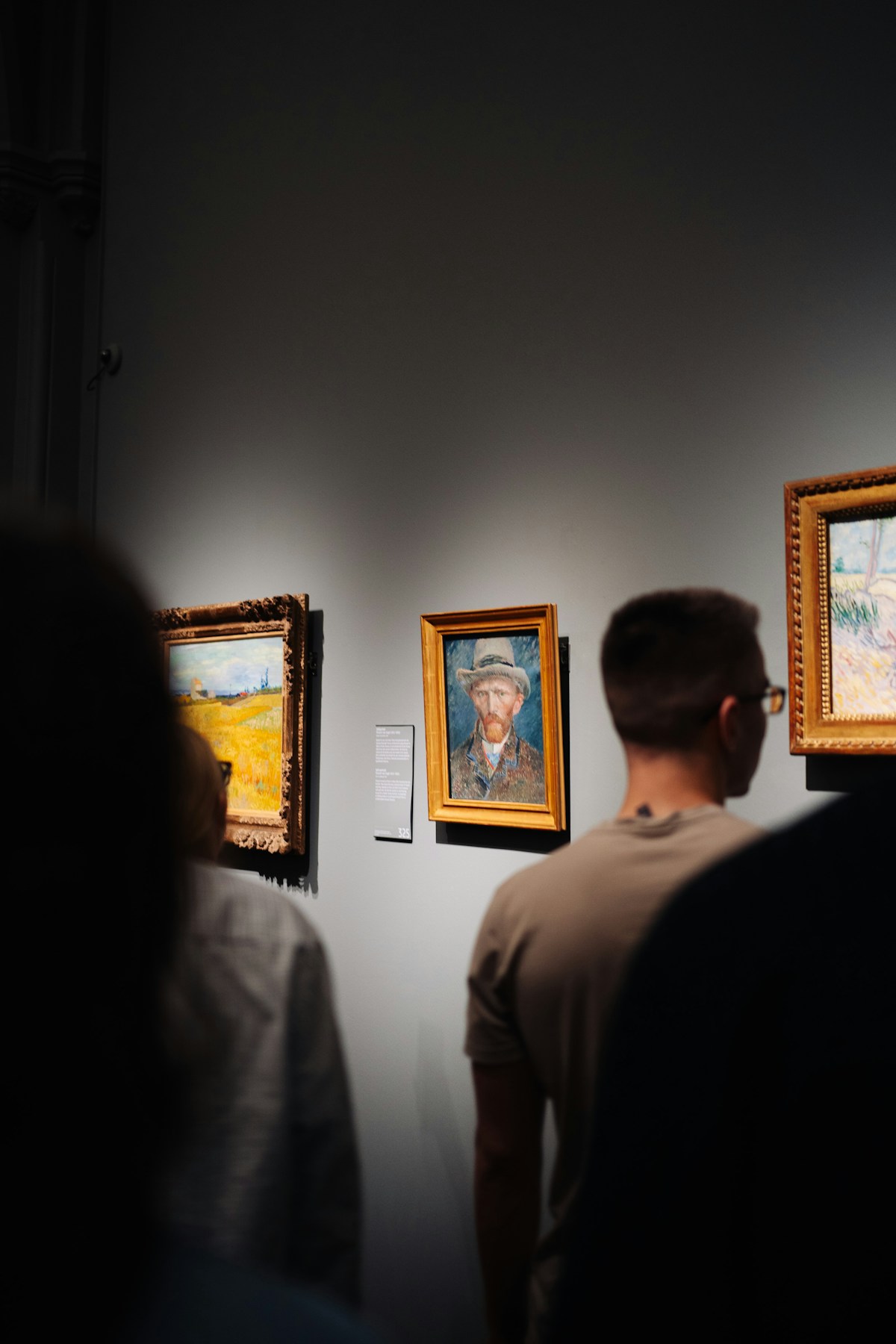 People viewing paintings in a museum gallery