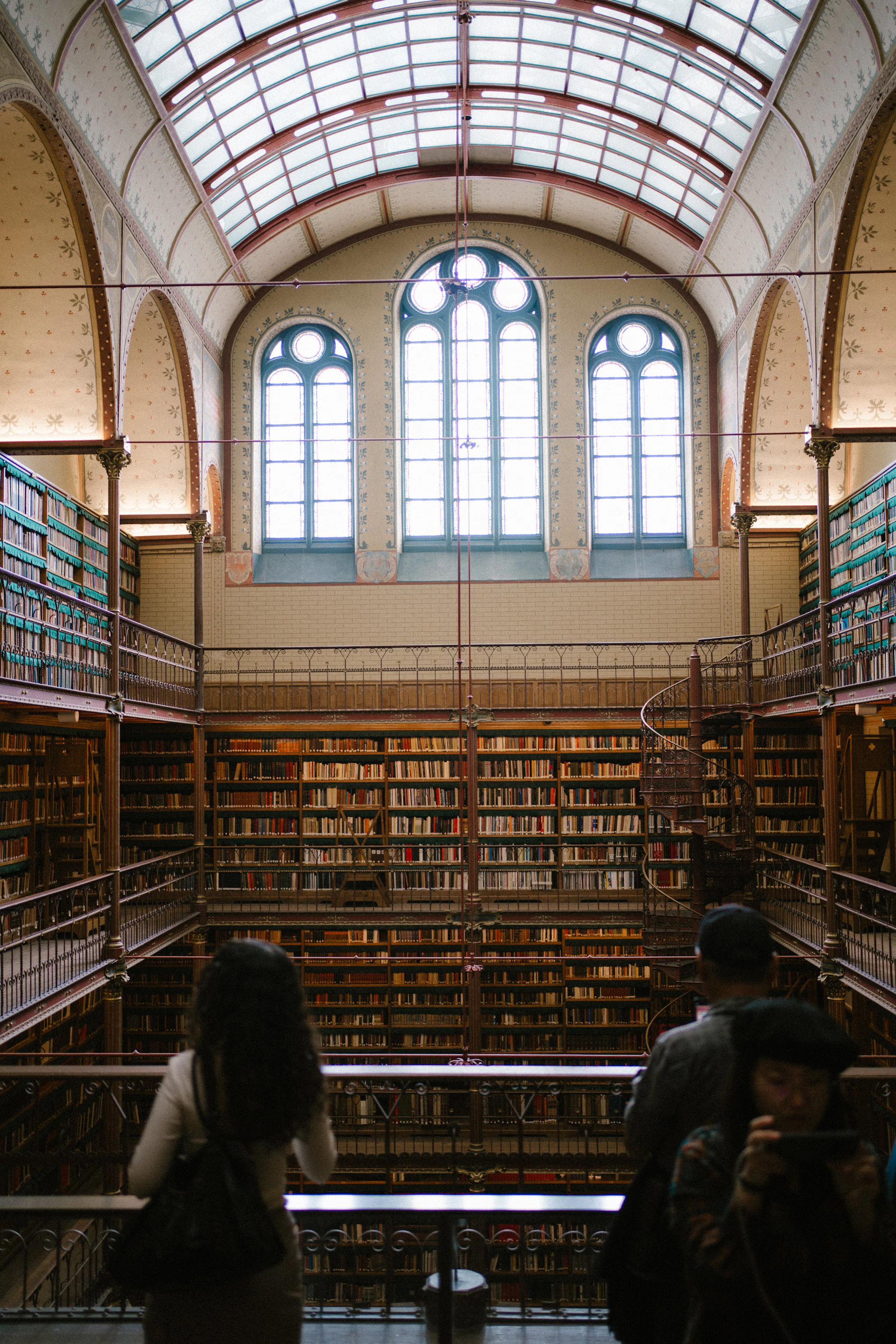 Grand library interior with tall bookshelves and arched windows